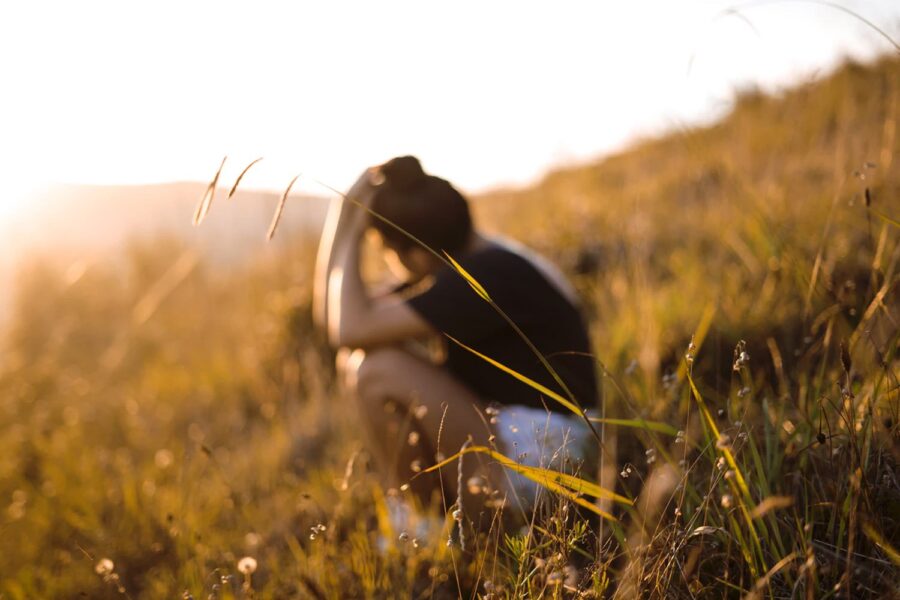 We Grieve community girl person sitting grieving field